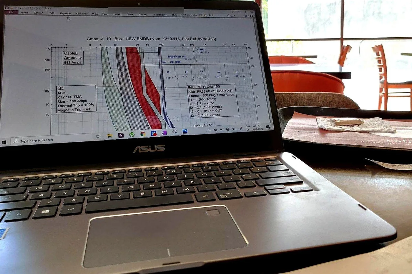 Protection coordination curves being graded on a laptop running ETAP