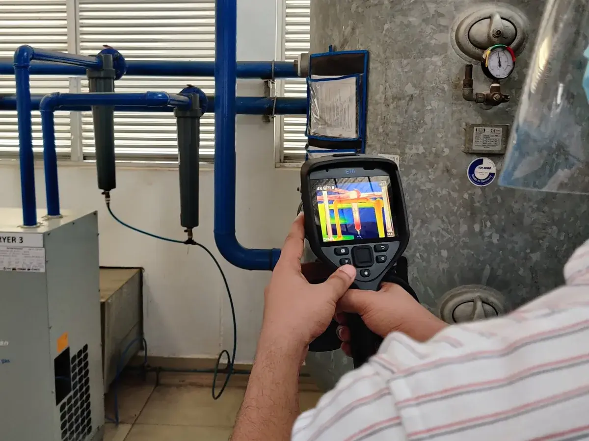 Vibhawa engineer using a thermal camera on the compressed air dryers and pipework of a factory compressor room during an energy audit
