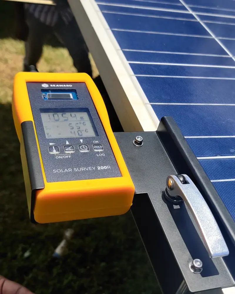 Solar Pv Consultancy 2 Seaward Solar Survey 200R irradiance meter clamped to a module frame, reading 1054 W/m2 with module temperature 55 C and ambient 40 C